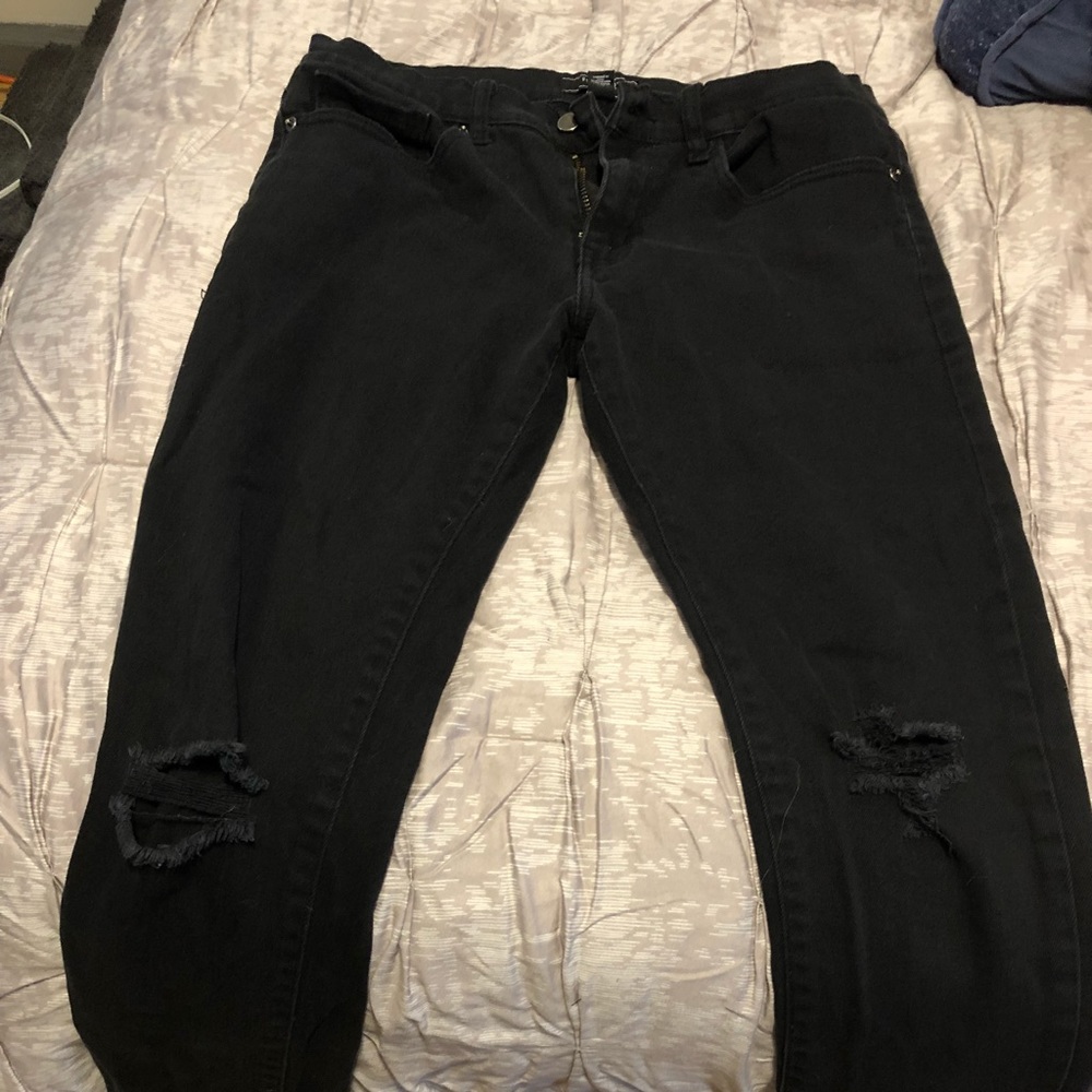 Used black jeans with holes at the knees